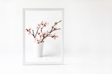 Flowers composition spring. Blank photo frame for text and peach blossom