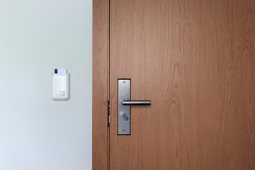Hotel key card door lock system. Wooden door with electronic lock. Front view. 