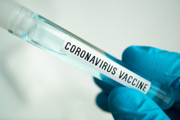 Obraz premium scientist holding test tube with covid-19 or coronavirus vaccine label, lab testing for inventing pandemic medication