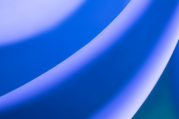 Macro photo. Abstract minimalistic background - paper art. Neon blue light, minimalism, copyspace. Waves, paper cut. 3D effect.