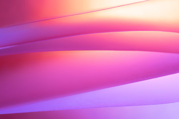 Macro photo. Abstract minimalistic background - paper art. Neon pink, yellow and blue light, minimalism, copyspace. Waves, paper cut. 3D effect.
