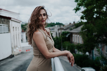 Fototapeta premium beautiful fashionable woman in a beige dress in the park on a walk