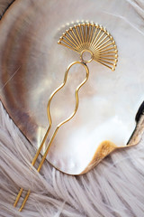 Brass metal yellow golden hair pin detail on natural rocky background