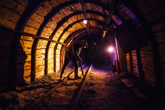 Miner working a jackhammer in a coal mine. Work in a coal mine. Portrait of a miner. Copy space.