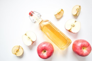 Apple cider vinegar or fermented fruit drink and organic apples on a white background, top view, copy space. Concept of healthy food and lifestyle