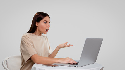 woman shows her emotions in a complaint, she put her palm in monitor and open her mouth, isolated.