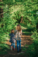 children walk along a path in the forest