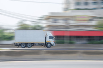 Motion image of the white truck driving on the road  with speed.