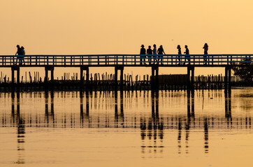 Fototapeta premium Wooden bridges and people against the sunset sky background, Silhouette image