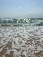 the sun shines on the blue sea and the sandy beach against the blue sky