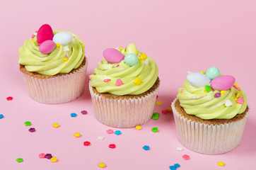 Row of bright pistachio Easter cupcake with decorations in hand close up