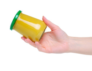 Glass jar mustard in a hand on white background isolation