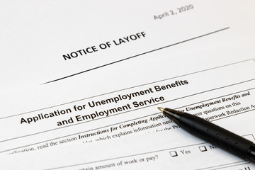 Job layoff notice and application for unemployment insurance benefits paperwork. Concept of Covid-19 coronavirus and stay at home order impact on economy