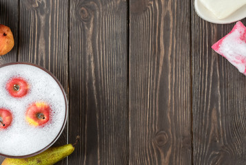 Washing fruits in a cup with foam after purchase, flat lay. Wash fruits after purchase to eliminate viruses, infections, and dirt.
