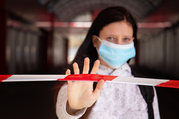 Kharkov, Ukraine, 3th april 2020: Young girl hold white-red restrictive lenght in hand in front of...