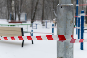 Begining of a quarantine of a coronavirus covid-19 in Moscow. Empty closed sports ground covered with snow and blocked by a barrier tape.