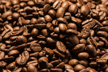 Grains of freshly roasted coffee close-up on a wooden background. Coffee beans texture