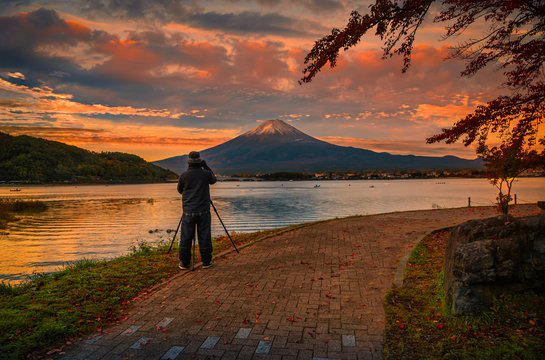 Rear view of Traveler man take photo Fuji mountain and kawaguchiko lake at sunset in Fujikawaguchiko, Japan.