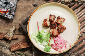 lunch grilled meat pork on vintage wood table in rustic style. Coals in the fire flame. BBC food.