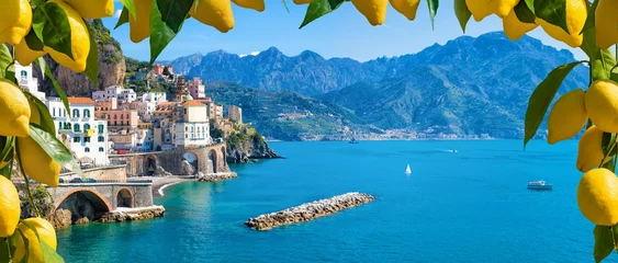 Fotobehang Kleine stad Atrani aan de kust van Amalfi in de provincie Salerno, regio Campania, Italië. De kust van Amalfi is een populaire reis- en vakantiebestemming in Italië. Rijpe gele citroenen op de voorgrond. © IgorZh