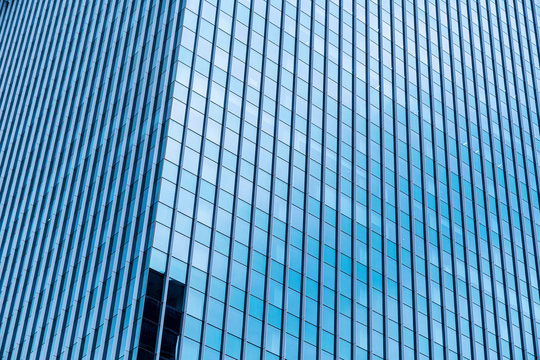 Abstract background from blue glasses window in high modern building in sunny day.