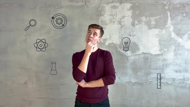 Online education. The image of a modern person who studies through the Internet. A young man stands against a gray wall, and around him are animated icons that show the distance learning system