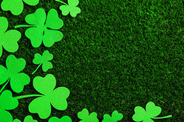 Flat lay composition with clover leaves on green grass, space for text. St. Patrick's Day...