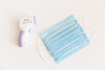 Medical protective mask with a thermometer on white background with pills. A disposable surgical face mask. Healthcare and medical concept.
Prevention of the Covid-19 pandemic virus. Quarantine.