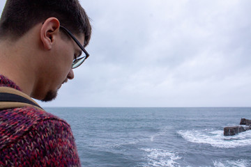 man looking at the sea from a viewpoint