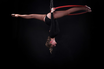 A female gymnast performing exercises on an air ring (hoop) © Oleksii