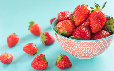 strawberries in a red bowl on a blue background