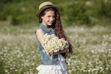 Beautiful teenage girl in a white dress and hat walking