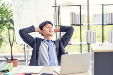 successful and confident entrepreneur asian businessman executive relaxing taking a break time from working in modern office, concept of company planning, brainstorming business ideas and strategies