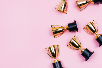 Winner cups on a pink background. Banner with a place for text. Flat lay style.