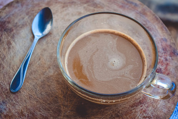 cup of coffee with  spoon on the wooden floor