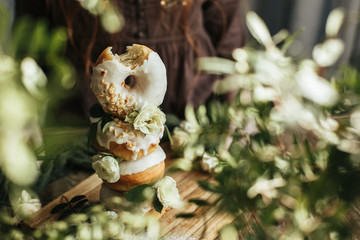 Donuts decorated with rose flowers on a wooden table
