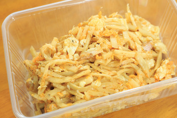Stir fried bamboo shoots with eggs In a plastic box on a wooden table