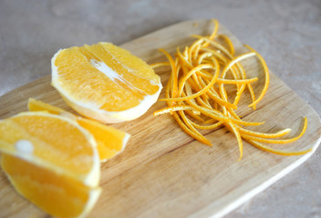 Sliced orange and orange zest on a wooden board