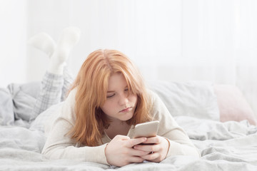 Obraz na płótnie Canvas teenager girl with smartphone on bed
