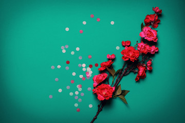 Colorful confetti and flowers on a turquoise background