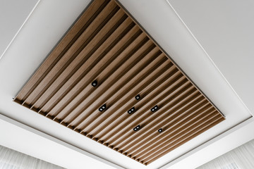 contemporary suspended wood ceiling,loft style ceiling,beautiful wooden ceiling,black light bulbs in a wooden ceiling,concrete wood ceiling,brown beams on the ceiling