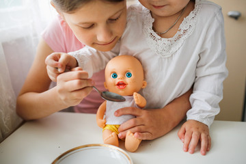 children play with doll, feed doll from spoon