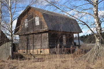 Old wooden house in village on sunny day in early spring