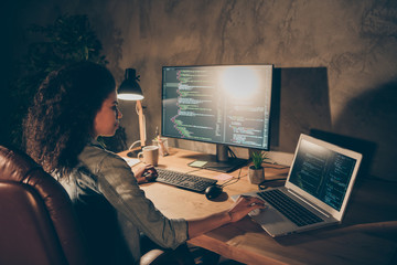 Back rear spine view photo focused skilled afro american software developer sit table desk evening...