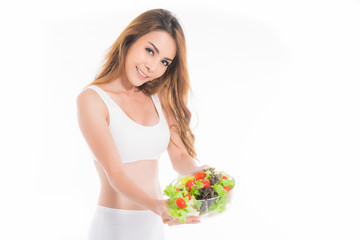 Girl in a white sport bra holds a salad bowl.