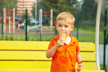 outdoor portrait of a little boy. child eating ice cream.