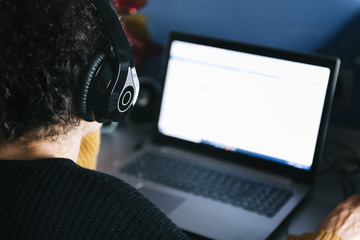 woman listening music with headphones on laptop