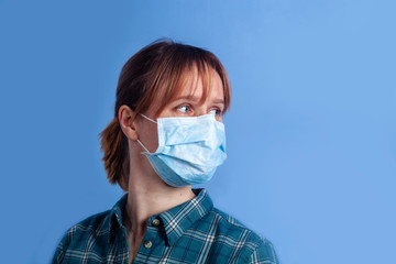 woman wearing facial mask for protection from air pollution or virus epidemic on blue background