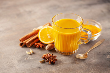 Obraz na płótnie Canvas Golden Cinnamon Lemon Turmeric Tea. Trendy hot Healthy drink with turmeric roots and spices. Wooden background
