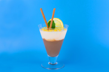 
Chocolate vanilla pudding in a glass on a light blue background.
Copy space.